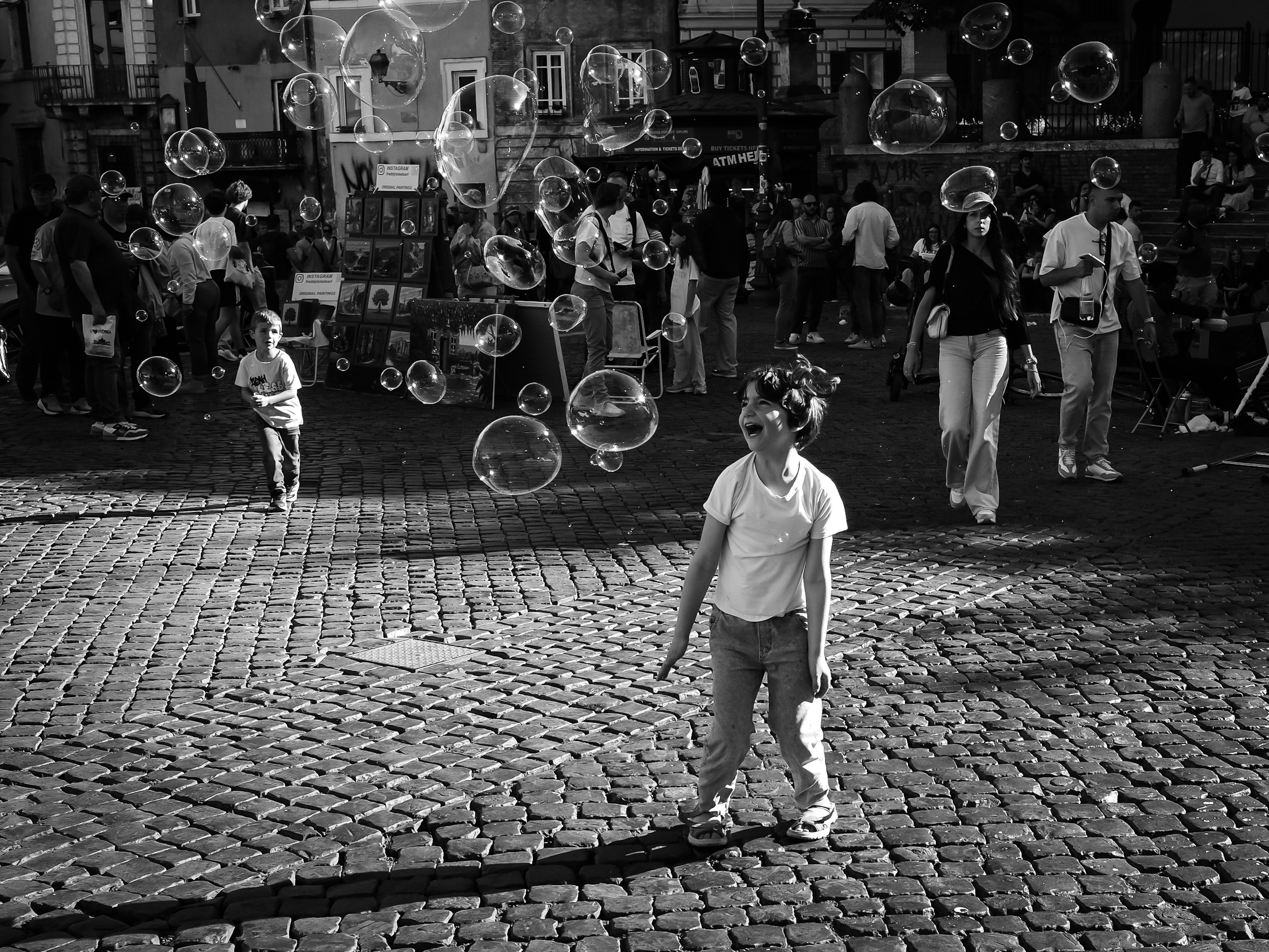 Child laughing among soap bubbles in a Roman piazza
