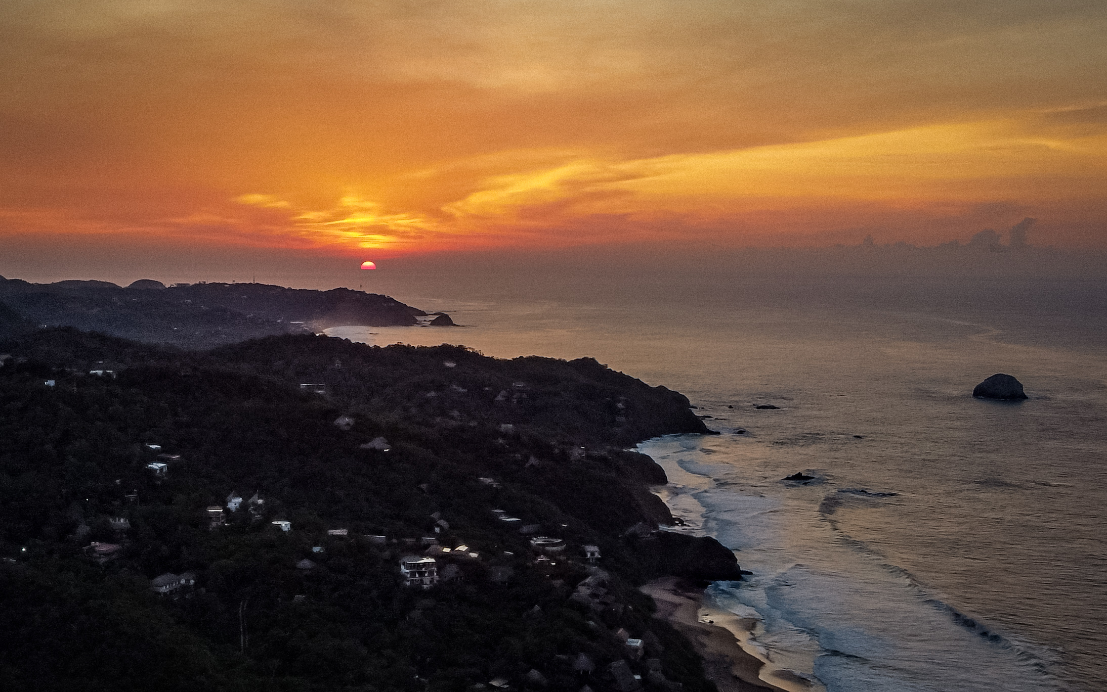 Aerial sunset over Pacific coast hillside, Mexico